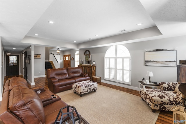 living room featuring hardwood / wood-style flooring and a raised ceiling