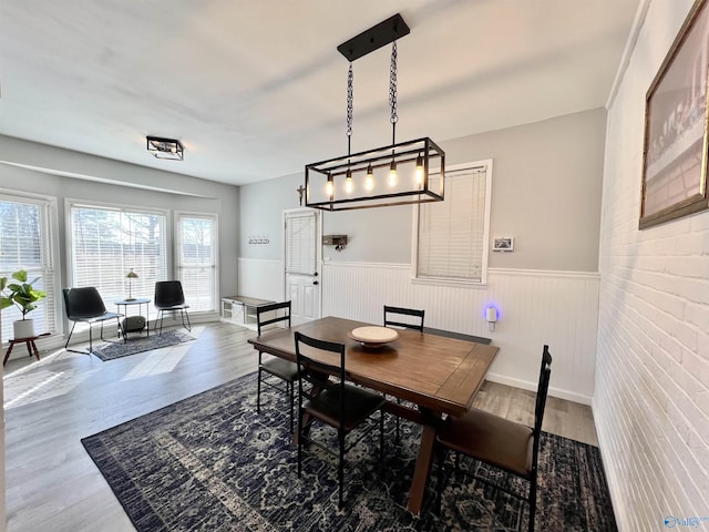 dining area featuring a wainscoted wall and wood finished floors