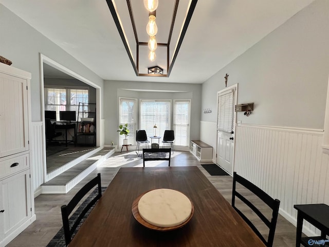 dining area featuring a wainscoted wall and wood finished floors