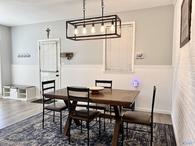 dining room with wood finished floors and wainscoting