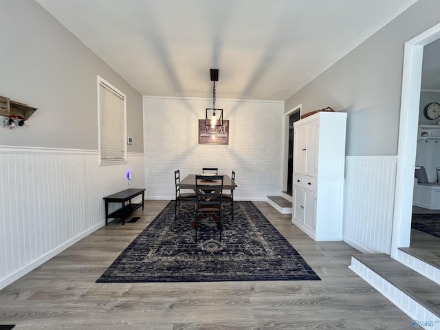 dining area with light wood finished floors and wainscoting