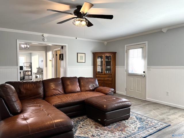 living area featuring ornamental molding, wainscoting, and wood finished floors