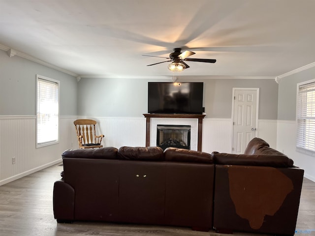 living area featuring wainscoting, a healthy amount of sunlight, and wood finished floors