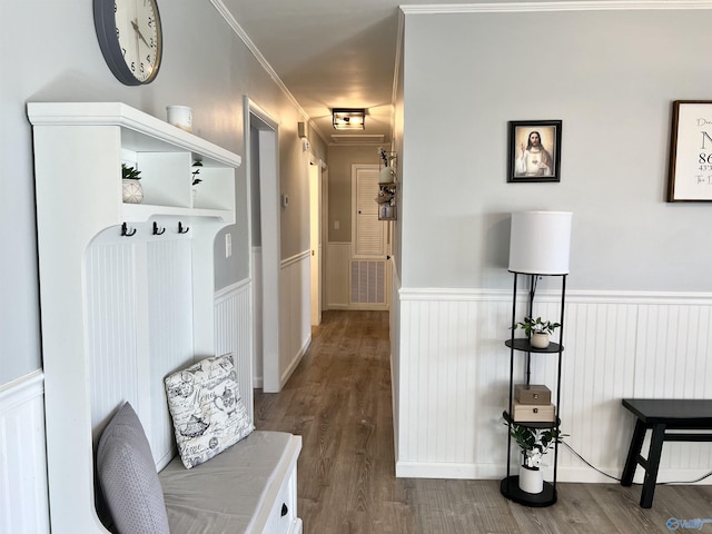 mudroom with ornamental molding, wood finished floors, and wainscoting