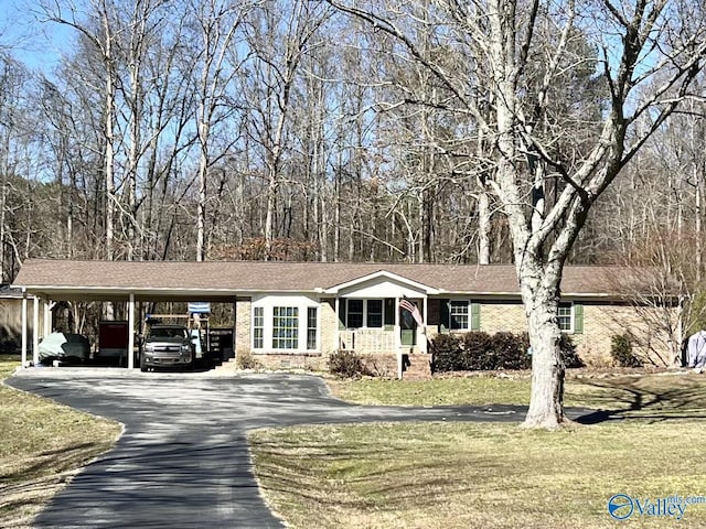 ranch-style home with a front lawn, aphalt driveway, an attached carport, and brick siding