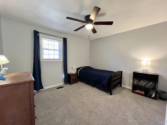 carpeted bedroom featuring ceiling fan, visible vents, and baseboards