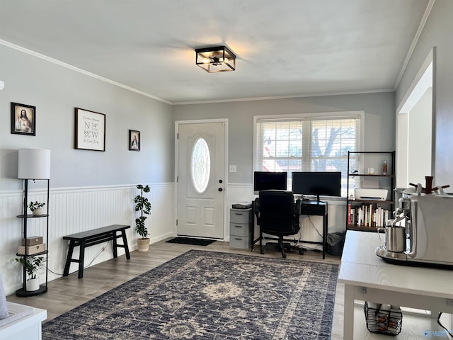 office space featuring a wainscoted wall, ornamental molding, and wood finished floors