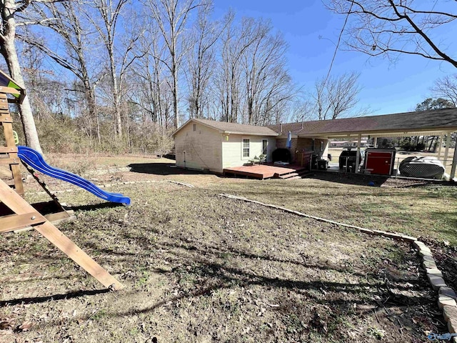 exterior space with a playground and a wooden deck