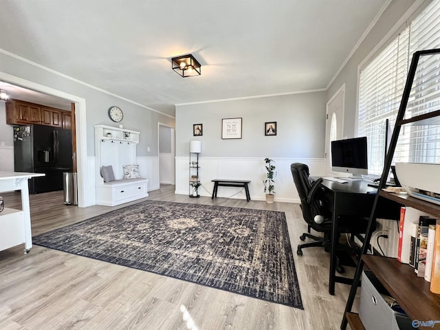 office space with light wood-type flooring, ornamental molding, and wainscoting