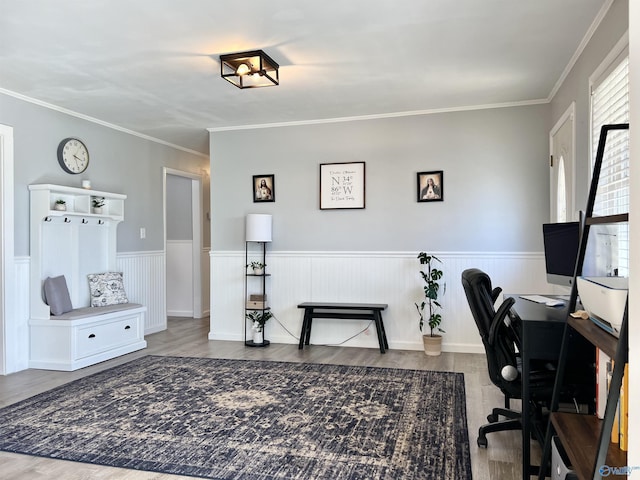 home office with a wainscoted wall, ornamental molding, and wood finished floors