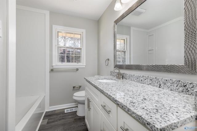 bathroom featuring toilet, wood finished floors, visible vents, vanity, and baseboards