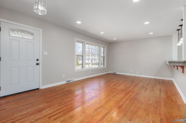 foyer entrance with light wood-type flooring, baseboards, visible vents, and recessed lighting