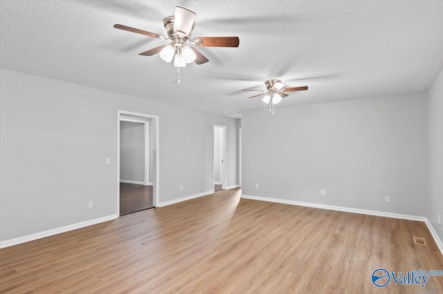 unfurnished room featuring a textured ceiling, baseboards, wood finished floors, and a ceiling fan