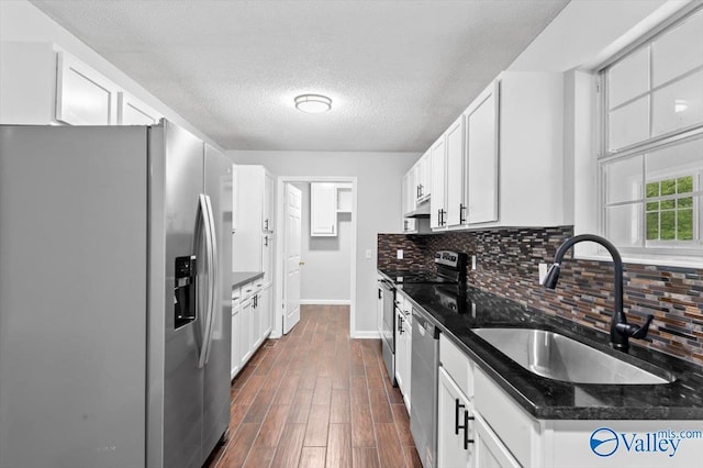 kitchen featuring backsplash, stainless steel appliances, baseboards, and a sink