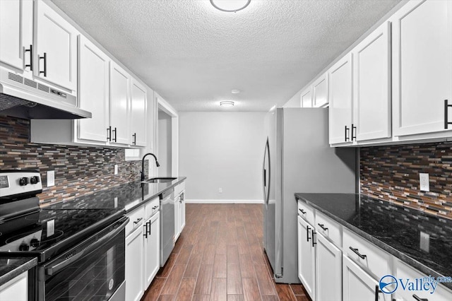 kitchen featuring a sink, dark wood finished floors, under cabinet range hood, white cabinetry, and appliances with stainless steel finishes