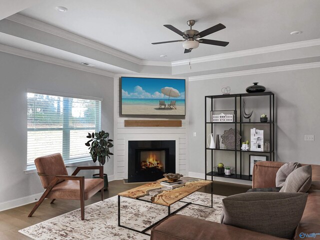 208 Fallow Cir, Madison, AL 35757 - living room with wood finished floors, ceiling fan, a fireplace, crown molding, and a tray ceiling