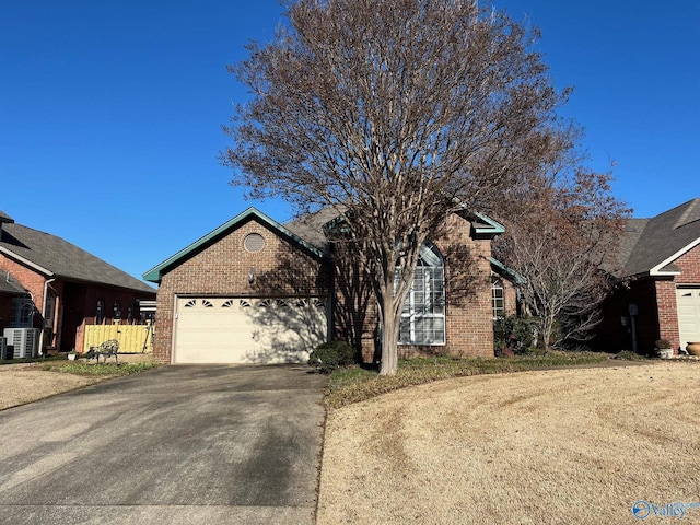 view of front of property featuring a garage and central AC