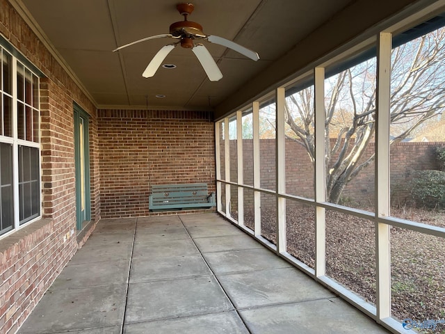 unfurnished sunroom featuring ceiling fan