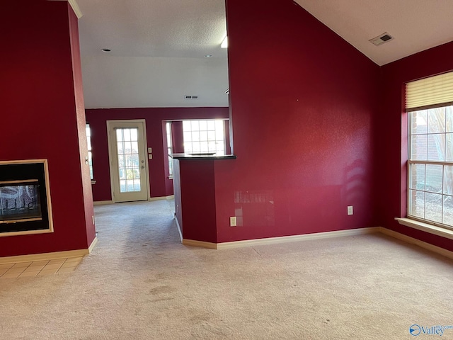 unfurnished living room with light carpet and lofted ceiling