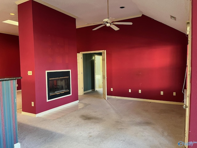 carpeted spare room featuring a textured ceiling, vaulted ceiling, and ceiling fan