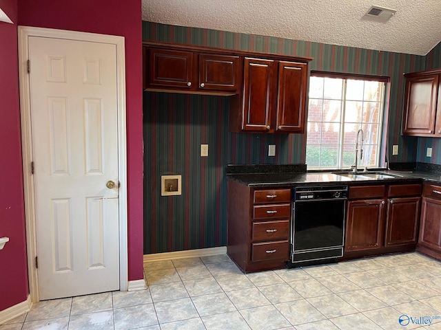 kitchen featuring a textured ceiling, light tile patterned flooring, sink, and black dishwasher