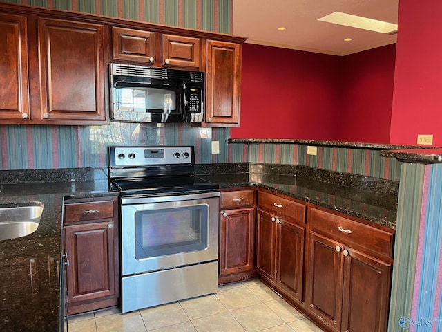 kitchen with sink, dark stone countertops, stainless steel range with electric cooktop, and light tile patterned flooring