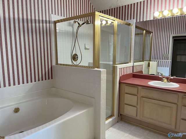 bathroom featuring vanity, independent shower and bath, and a textured ceiling