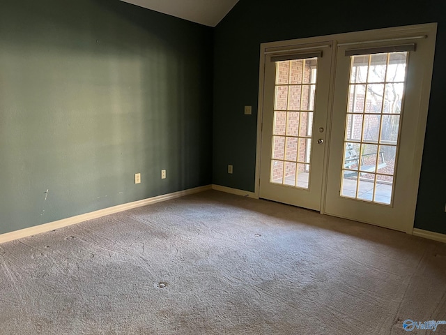 unfurnished room with carpet flooring, lofted ceiling, and french doors