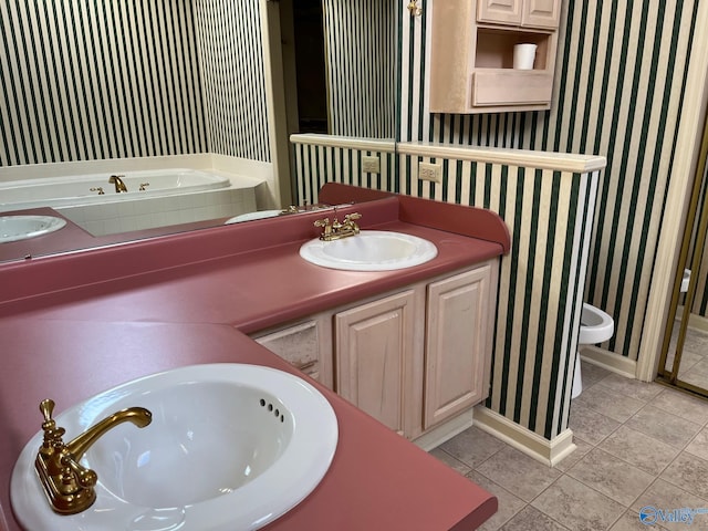 bathroom with tile patterned flooring, vanity, a bath, and toilet