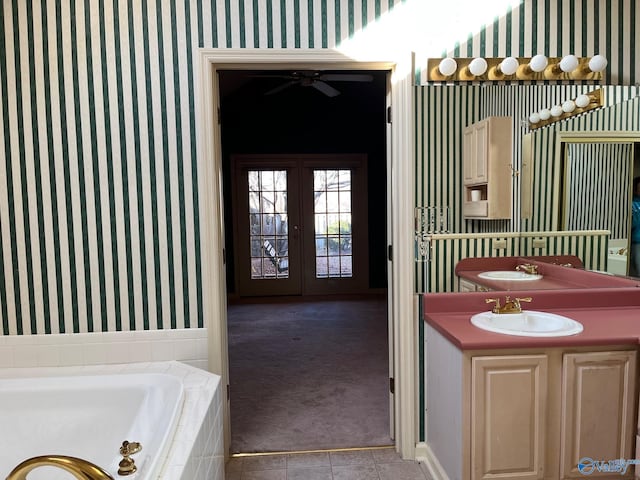 bathroom featuring vanity, a relaxing tiled tub, and french doors