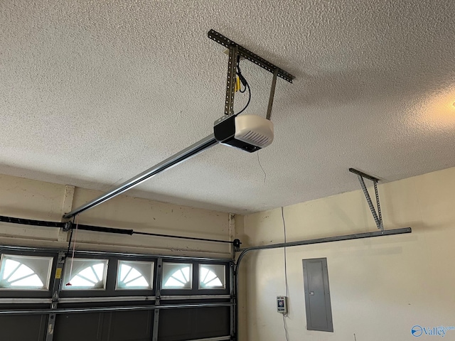 interior space with a garage door opener, a textured ceiling, and electric panel