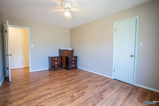 unfurnished bedroom with a ceiling fan, baseboards, and wood finished floors