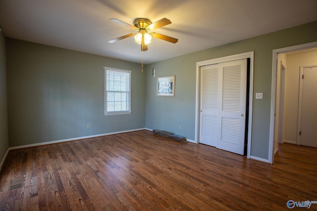 unfurnished bedroom with a ceiling fan, a closet, baseboards, and dark wood-style flooring