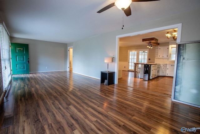 unfurnished living room featuring ceiling fan, dark wood-style flooring, and baseboards