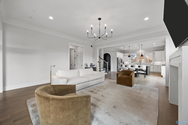 living room featuring ornamental molding, a chandelier, and light wood-type flooring