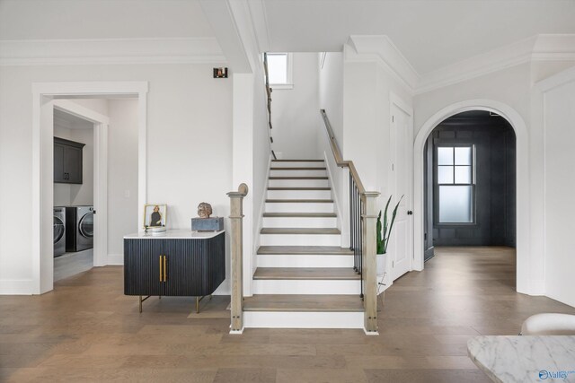 stairs featuring hardwood / wood-style flooring, a healthy amount of sunlight, and washer and dryer