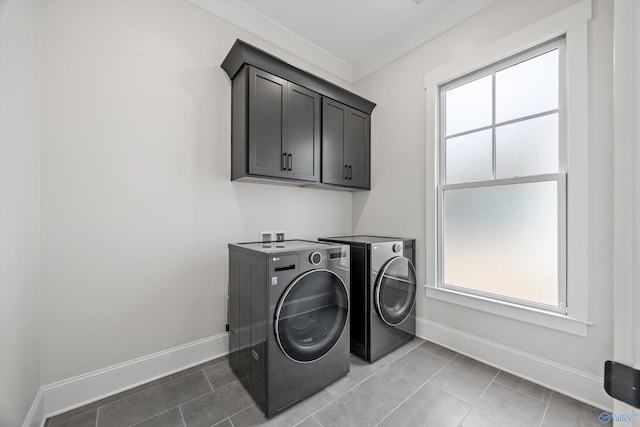 laundry area with cabinets, plenty of natural light, separate washer and dryer, and tile patterned flooring