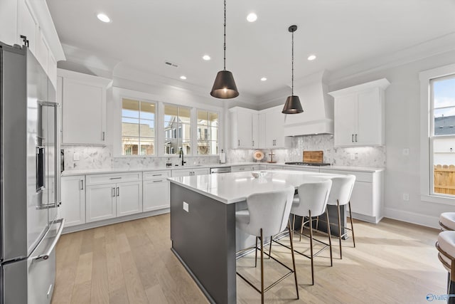 kitchen with a kitchen island, white cabinetry, and appliances with stainless steel finishes