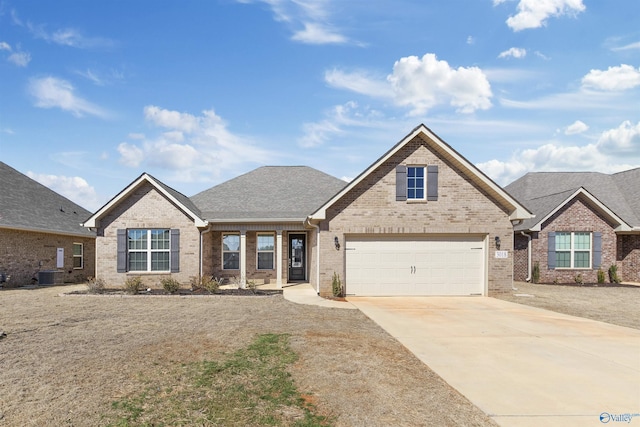 traditional-style home with a shingled roof, concrete driveway, brick siding, and central air condition unit