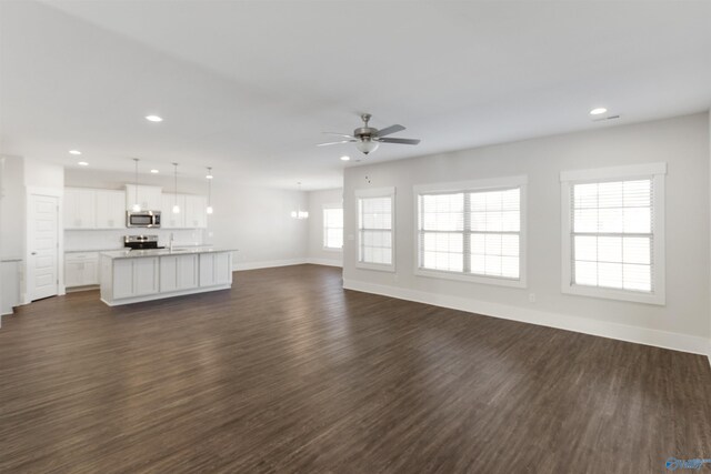 unfurnished living room with a ceiling fan, recessed lighting, dark wood-style flooring, and baseboards