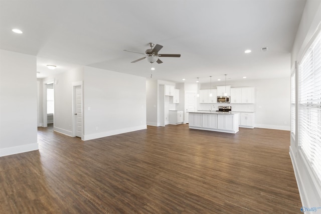 unfurnished living room featuring baseboards, dark wood finished floors, a ceiling fan, and recessed lighting