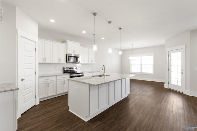 kitchen featuring dark wood-style floors, appliances with stainless steel finishes, white cabinets, and a sink