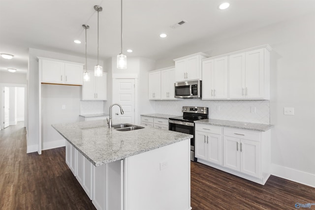 kitchen with visible vents, appliances with stainless steel finishes, a kitchen island with sink, white cabinetry, and a sink