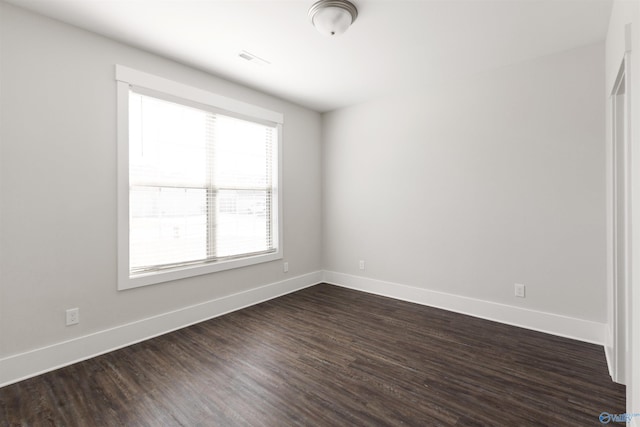 unfurnished room featuring dark wood-style flooring and baseboards