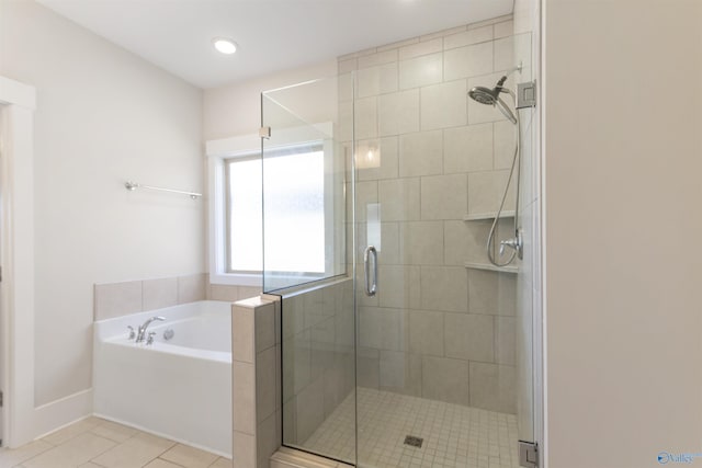 full bath with a stall shower, baseboards, a bath, and tile patterned floors