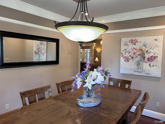 dining space with crown molding and baseboards