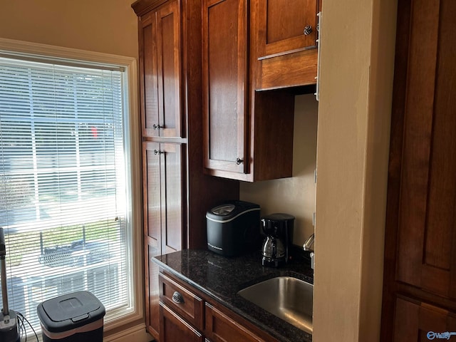 kitchen featuring dark stone countertops and sink