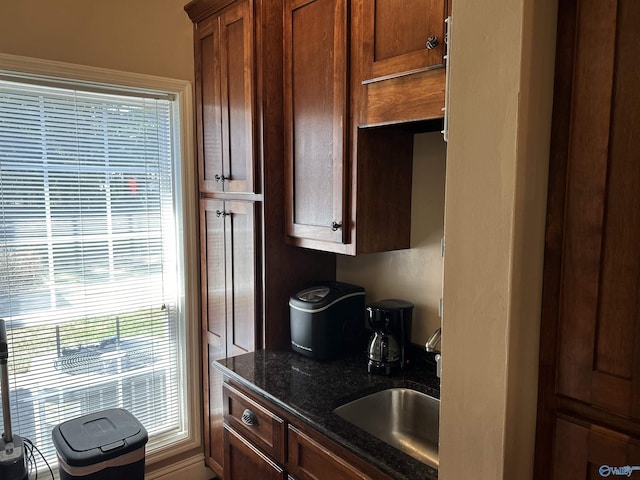 kitchen with dark stone countertops and a sink