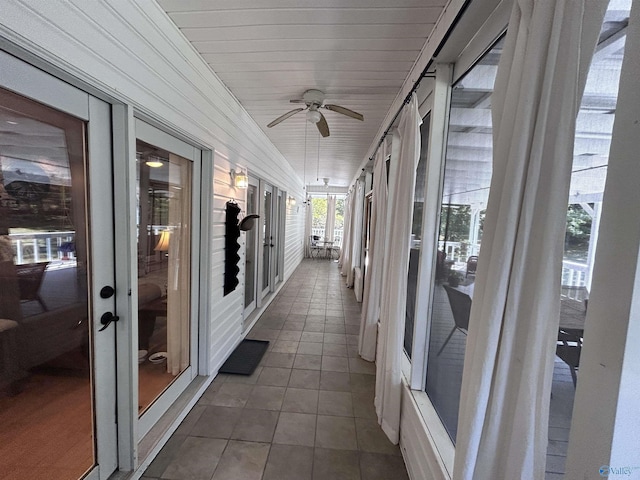 unfurnished sunroom featuring wood ceiling and ceiling fan