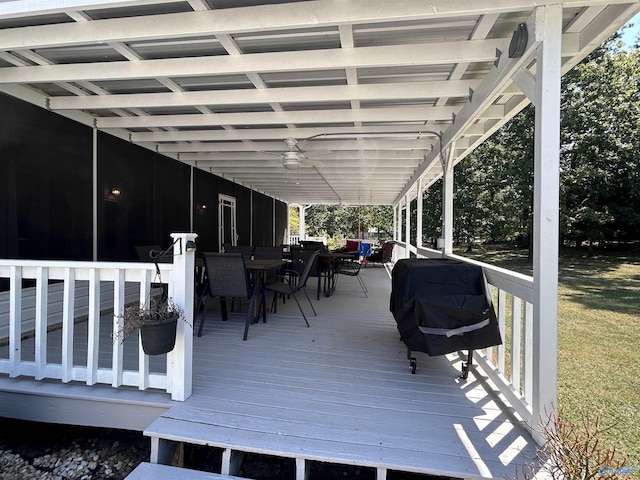 wooden terrace with a grill, outdoor dining area, and ceiling fan